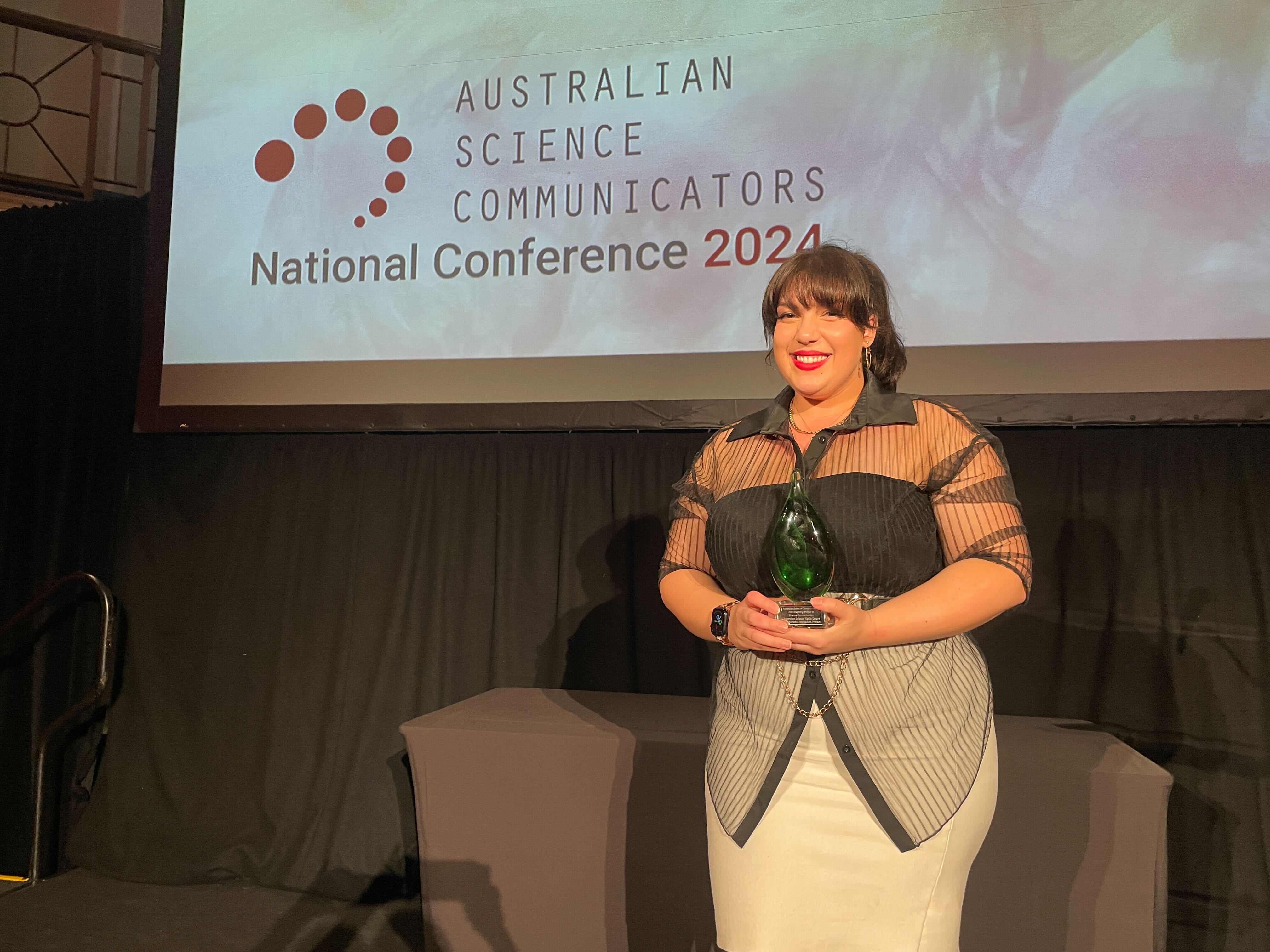 The  AusSMC's Olivia Henry accepts the Inspiring Project in Science Communication award at the Australian Science Communicators conference  in Perth